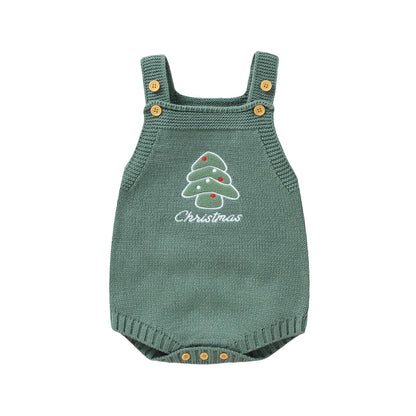 A flat product shot of a sleeveless green knit baby romper featuring a white embroidered Christmas tree and wooden buttons on the straps