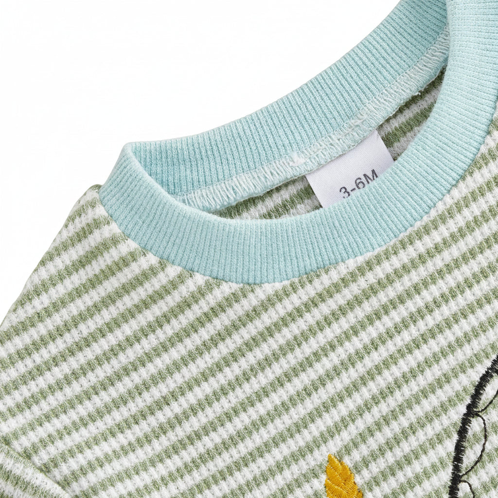 Close-up of the light blue ribbed crew neckline and breathable green and white striped waffle knit fabric of the baby boy romper.