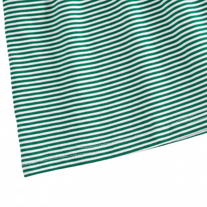 Close-up of the green and white horizontal striped cotton blend fabric and hemline of the toddler dress.