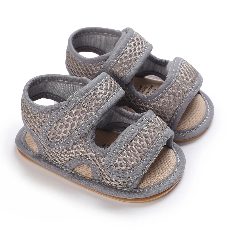 Grey first walker mesh sandals for babies, featuring a flexible developmental sole and mesh upper.