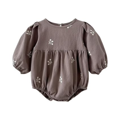 Flat lay of a grey long-sleeve cotton baby romper featuring brown floral embroidery.