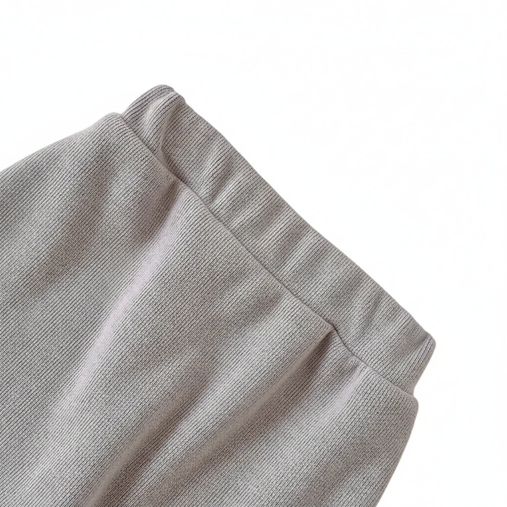 Close-up of the stretchy, comfortable elastic waistband on the grey knit baby play pants.