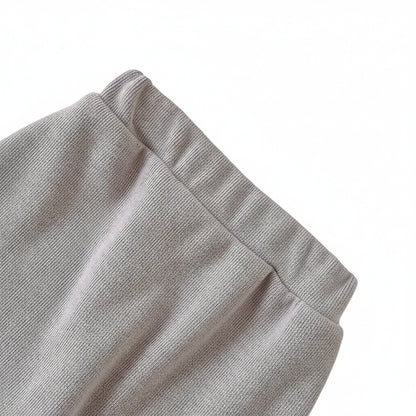 Close-up of the stretchy, comfortable elastic waistband on the grey knit baby play pants.