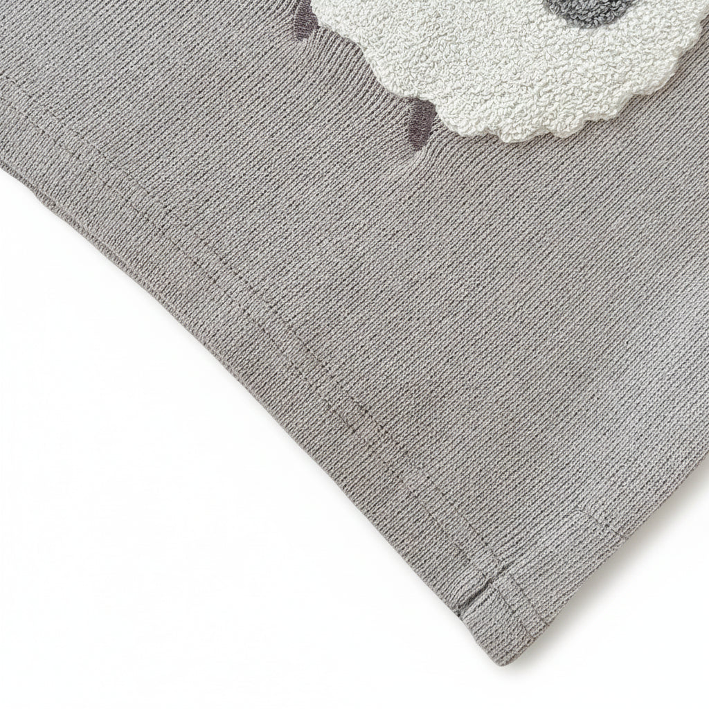 Close-up of the bottom hem stitching on the grey knit baby sheep sweater.