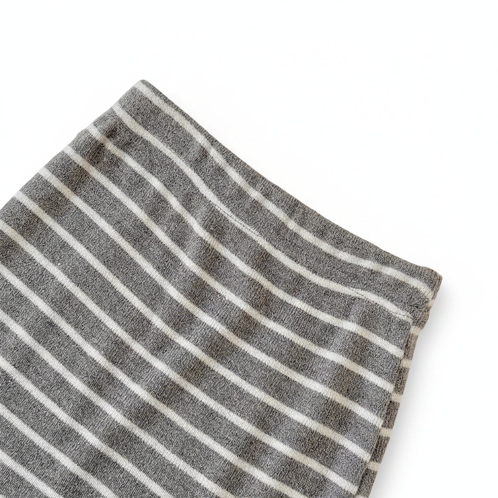 Close-up of the comfortable elastic waistband and ribbed fabric texture on the grey and white striped baby pull-on pants.