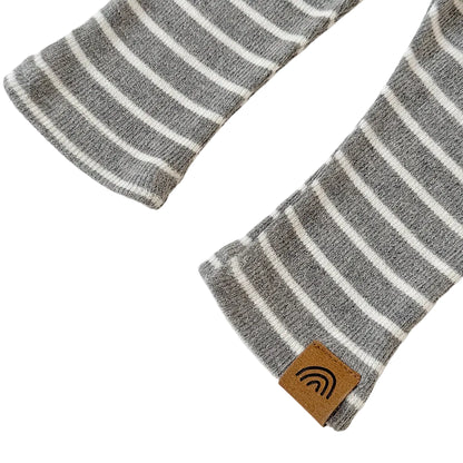 Close-up of the ankle hems on the grey striped toddler pants, showing a small brown rainbow tag on one of the cuffs.