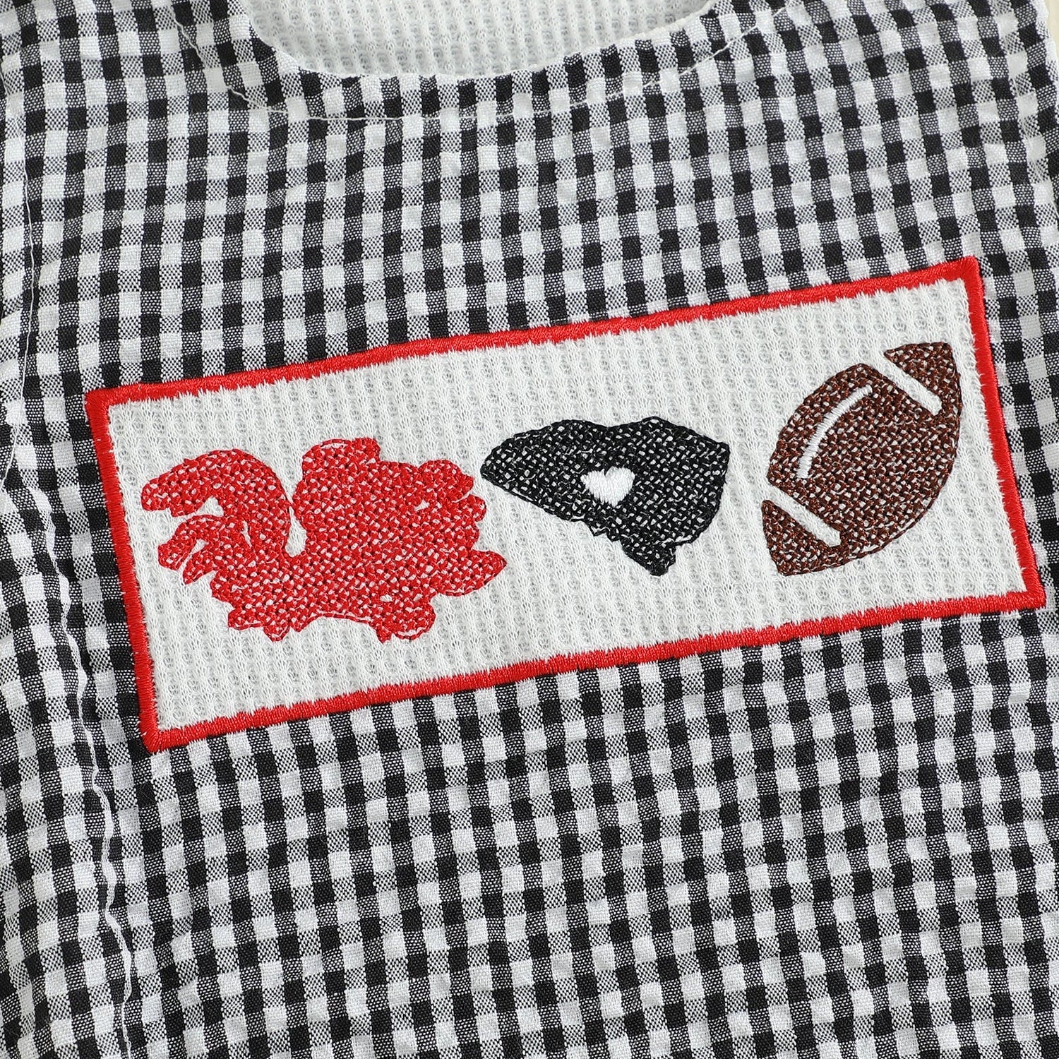 Micro detail of the hand-smocked chest panel on the baby romper, displaying an embroidered red rooster character design, black state map outline, and a classic brown football.