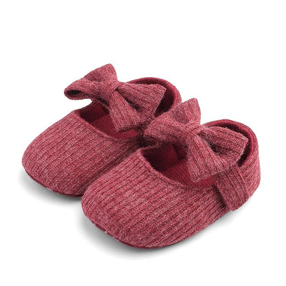 Pair of heather red textured ribbed knit Mary Jane crib shoes with front bows.