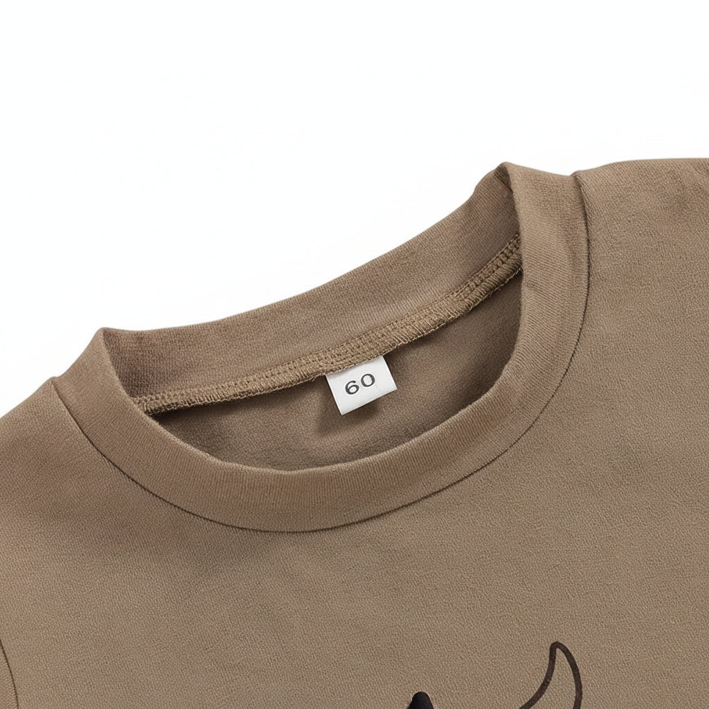 Close-up of the round neckline and size tag on the light brown baby romper.
