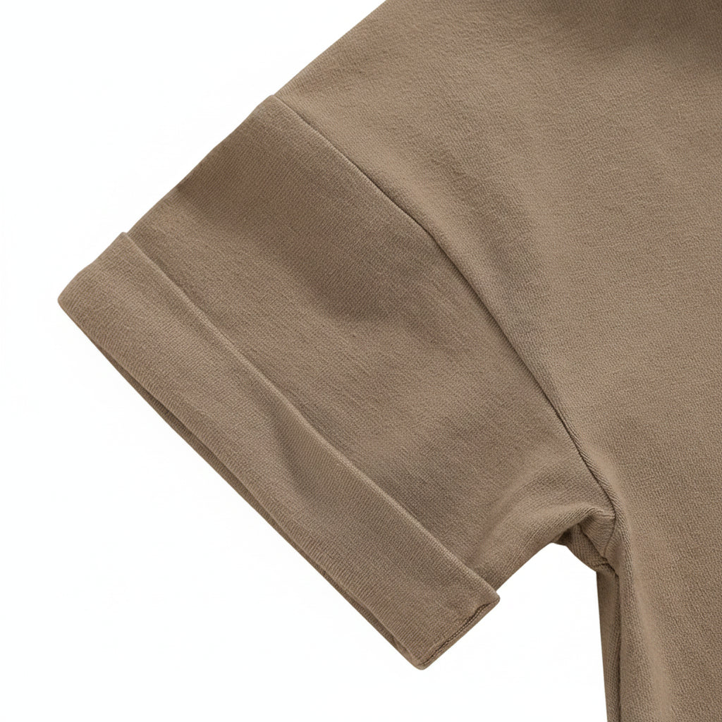 Close-up of the folded short sleeve detail on the light brown baby romper.