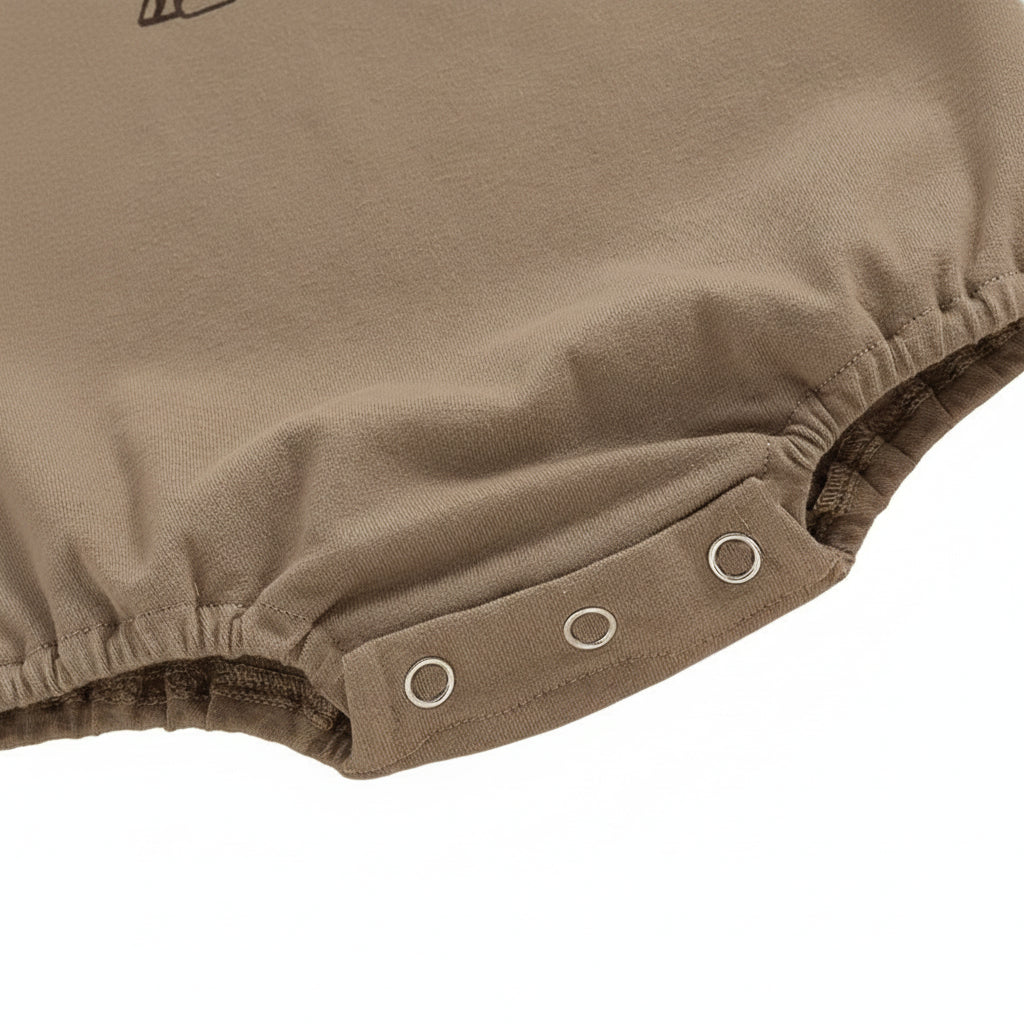 Close-up of the three bottom snap buttons for easy diaper changes on the baby romper.