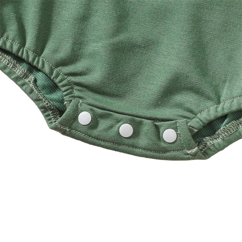 Close-up view of the three secure white plastic snap closures along the bottom hem of the baby bubble romper for quick diaper changes.