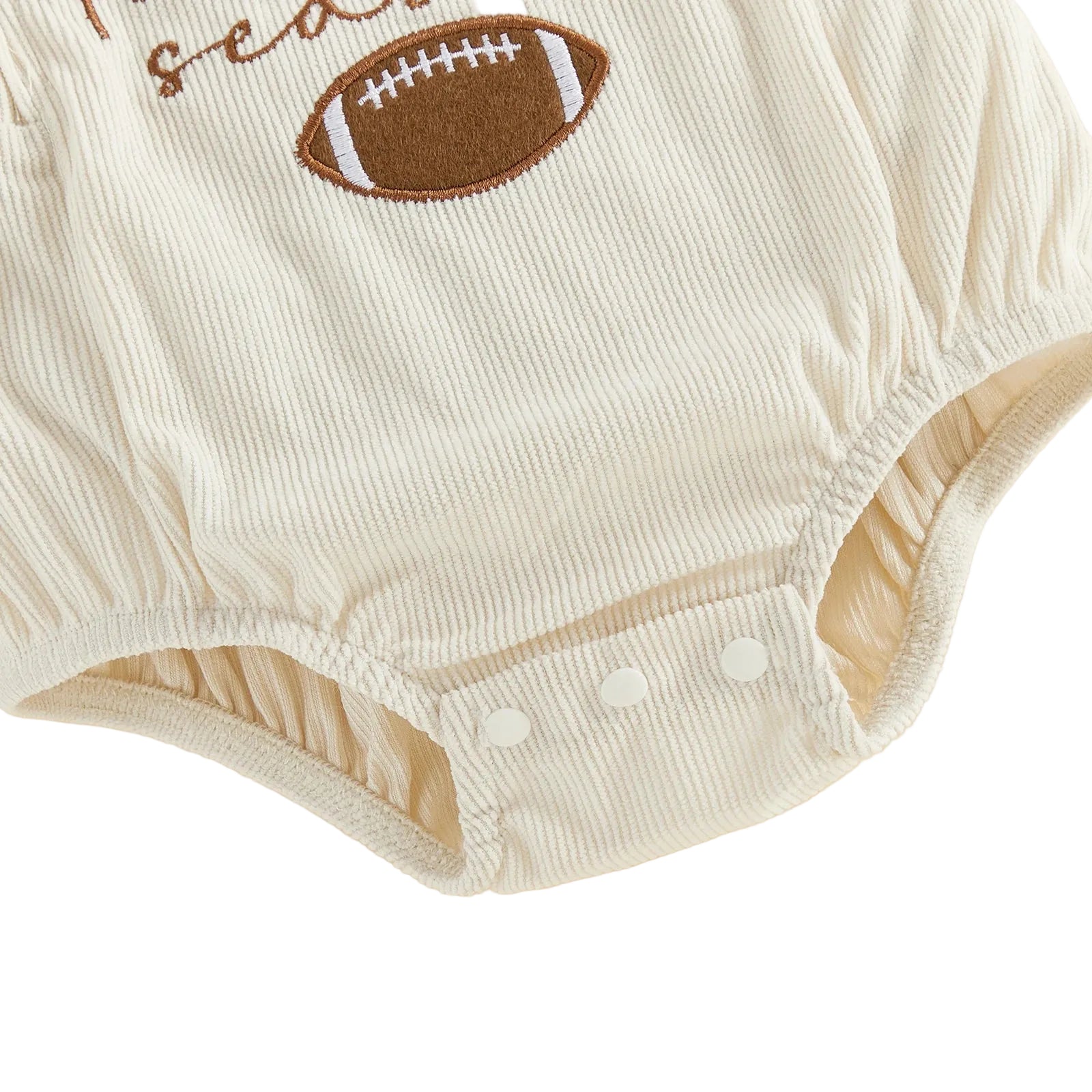 Detailed view of the elasticized leg openings and the secure three-button bottom diaper snap closures on the cream corduroy bubble romper.