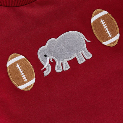 Close-up of high-quality vintage chain-stitch embroidery featuring a grey elephant and classic footballs on a crimson infant romper.
