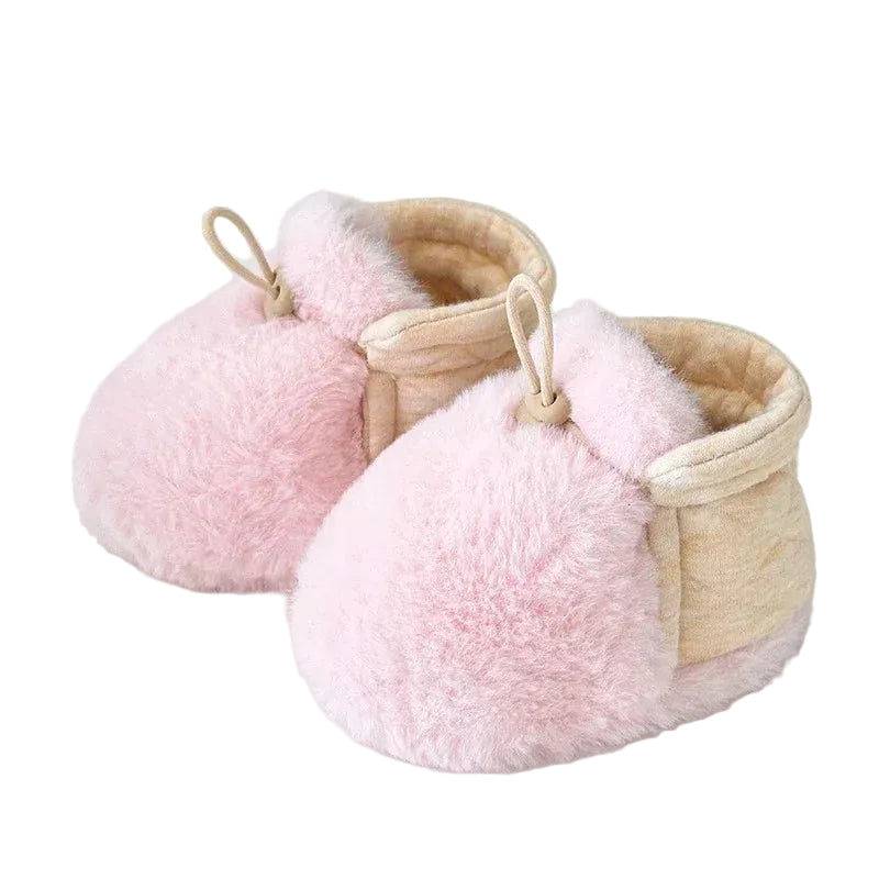 A pair of pink infant soft fleece booties with an adjustable elastic strap.