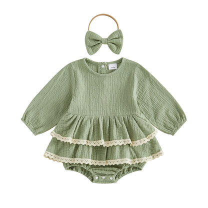 Sage green vintage-inspired infant girl puff sleeve romper dress with lace trim and matching bow headband on a white background.