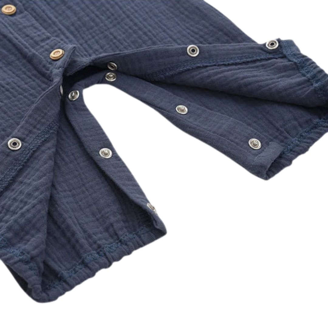 Detail shot showing the concealed inner-leg snap closures on the navy baby jumpsuit for quick diaper changes.