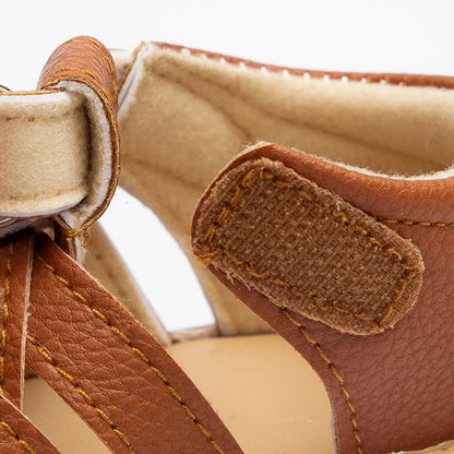 Macro close-up of the supportive covered heel counter and padded inner ankle lining on kidsely infant sandals.