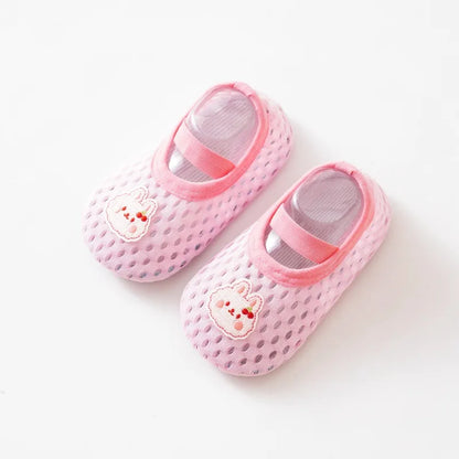 Pink infant swimming shoes with a decorative bunny rabbit patch and secure elastic strap.