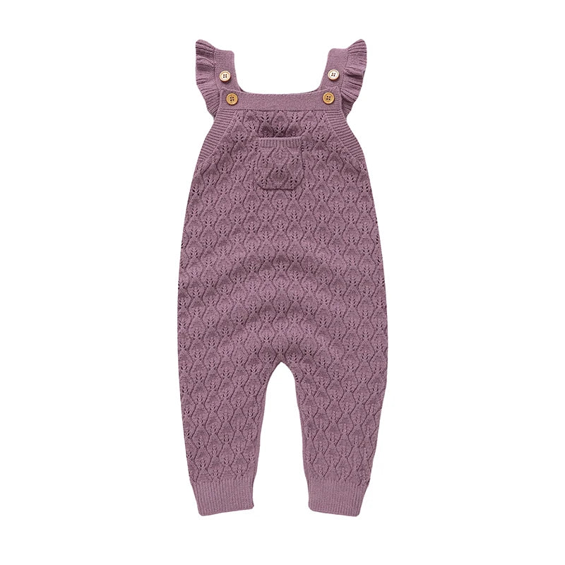 Full front view of a soft mauve baby girls chunky knit jumpsuit with suspender straps and ribbed ankles.
