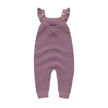 Full front view of a soft mauve baby girls chunky knit jumpsuit with suspender straps and ribbed ankles.