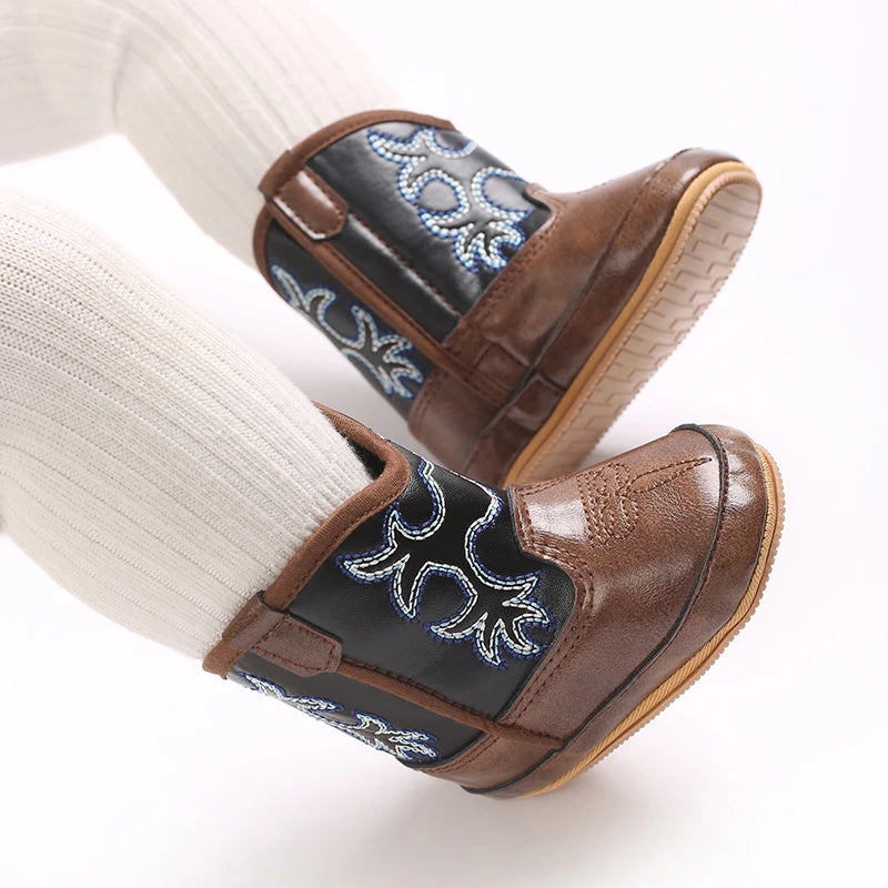Infant wearing flexible rubber sole brown two-tone cowboy boots with white tights.