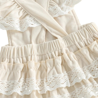 Close-up of the back of the ivory 6-month baby girl romper showing the cross-back straps and cute lace trim ruffle butt design.