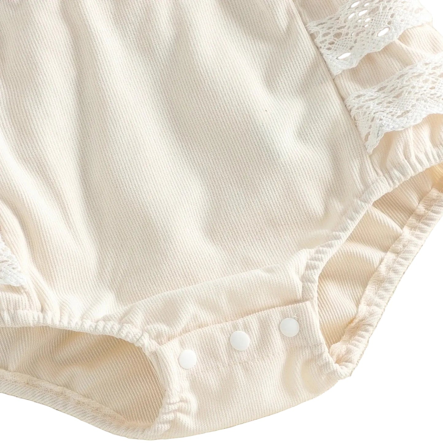 Close-up of the bottom of the ivory baby girl romper showing the convenient snap closures for diaper changes.