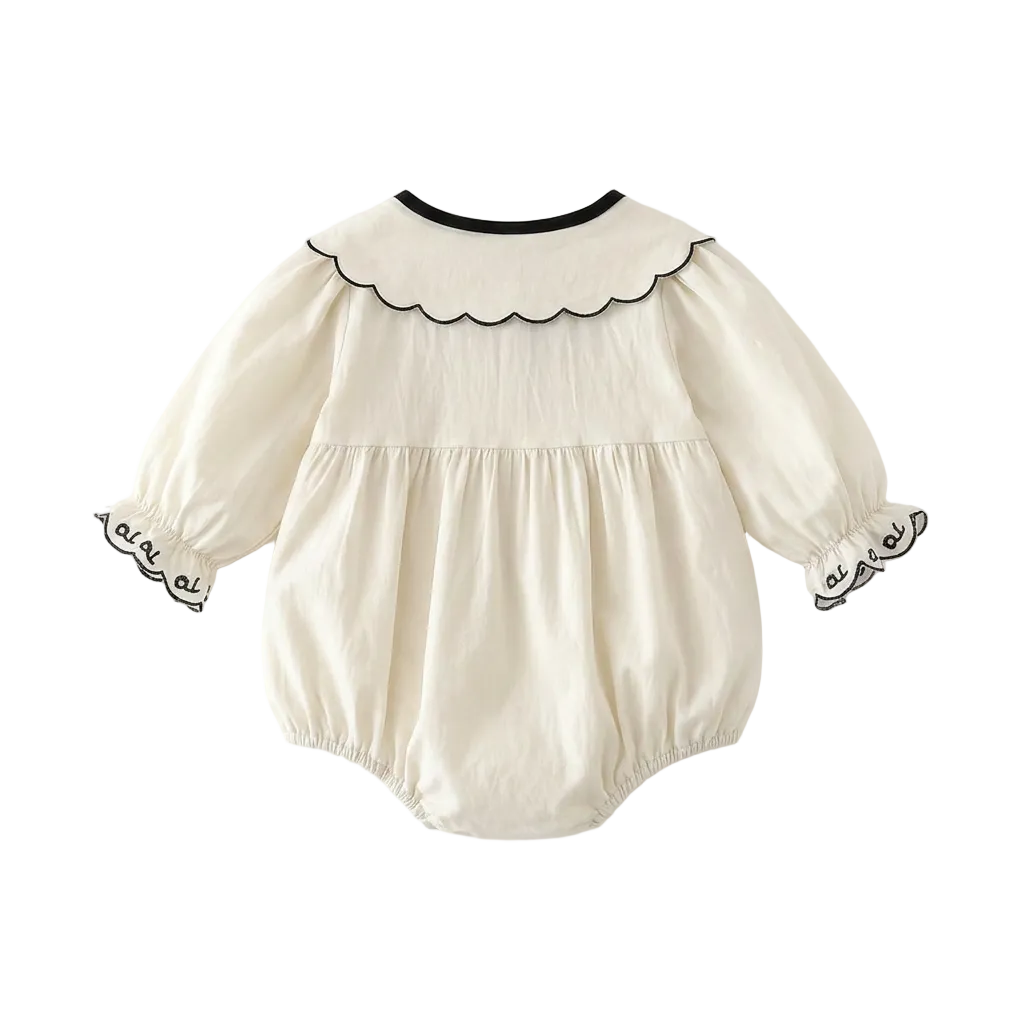 The back view of the long sleeve ivory bubble romper highlighting the clean collar line and roomy silhouette.