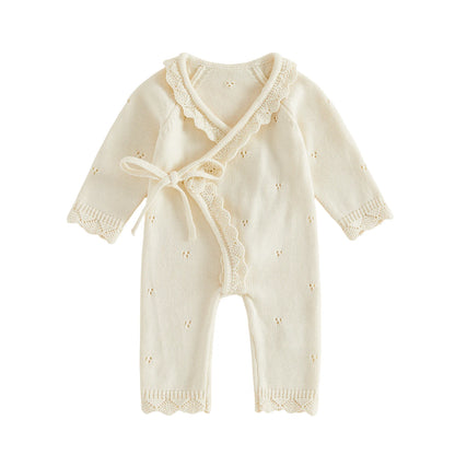 Ivory pointelle knit baby girl kimono romper with scalloped trim and side tie on a white background.
