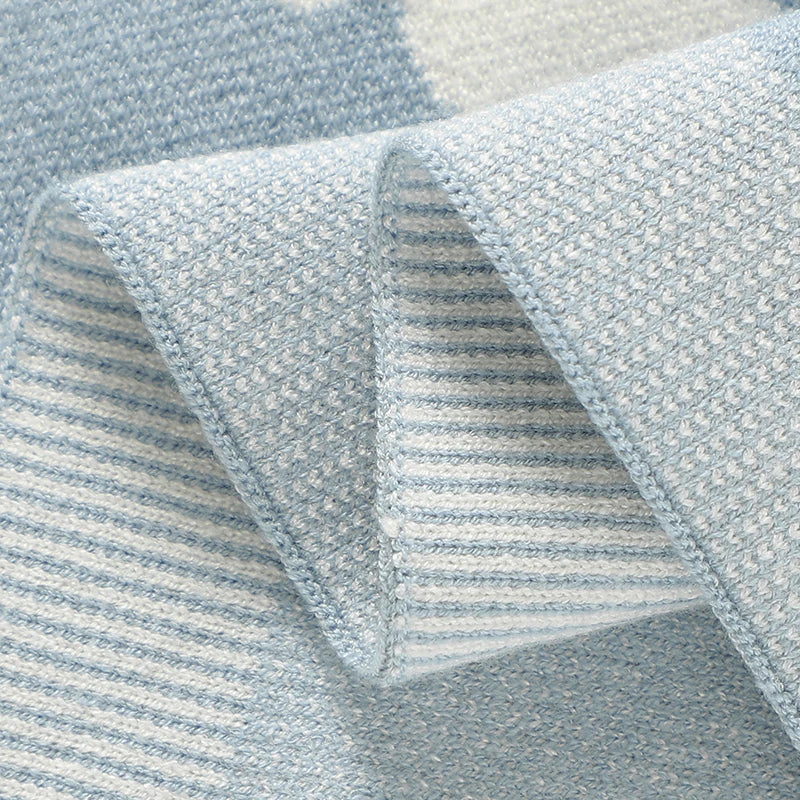 Close-up detail of the durable ribbed hem and border stitching on the whale knit baby blanket