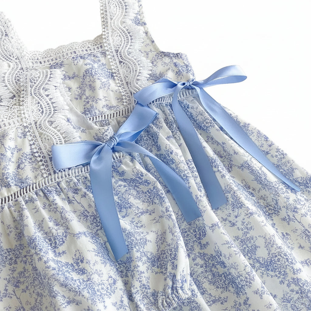 Close up of the intricate lace bodice and blue satin side-tie bow on the girls toile dress.