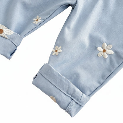 Close-up of the folded ankle cuff on light blue Kidsely overalls, highlighting the clean stitching and scattered white daisy embroidery.