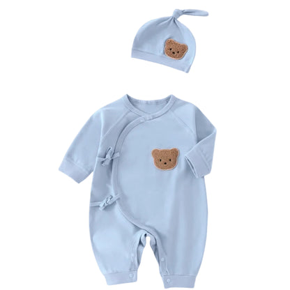 Light blue newborn side-snap jumpsuit and matching knotted beanie set with a cute bear face patch.