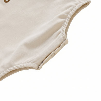 Close-up view of the secure premium snap button closure on the bottom of the baby girl romper for easy diaper changes.