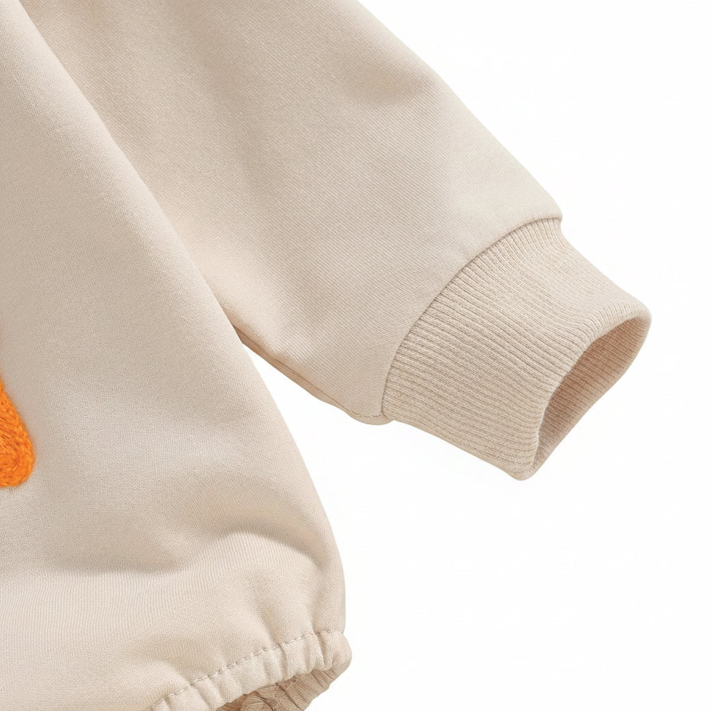 Close-up detail of the long sleeve and snug ribbed cuff on the neutral beige Little Bean baby romper.