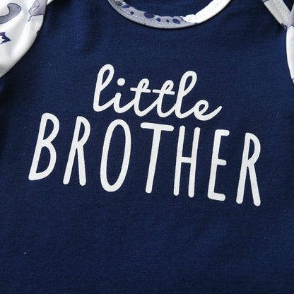 Extreme close-up of the white little BROTHER graphic text printed on the front of the navy blue baby bodysuit.