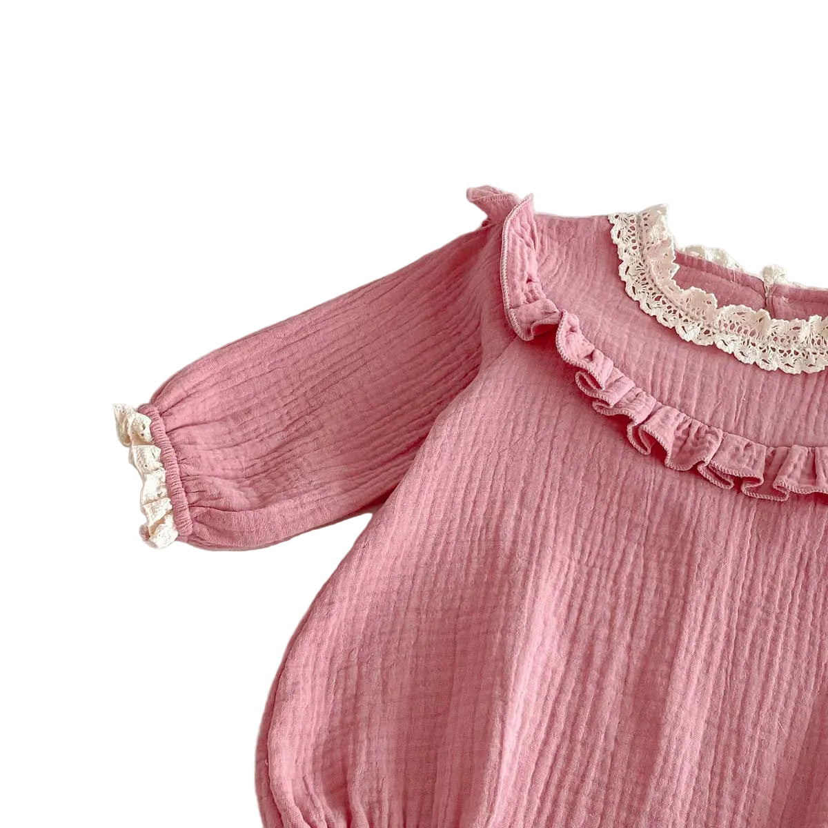 Close-up view of the right shoulder ruffle and long sleeve on a crinkle cotton dusty pink baby girl romper.