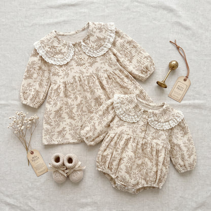 Flat lay of matching cottagecore floral baby romper and toddler dress set with vintage baby booties and accessories.