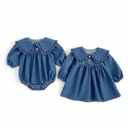 Matching baby girl blue denim romper and toddler sister denim dress laid flat together on a white background.