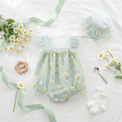 Mint green baby romper with daisy pattern, matching hat, and baby items on a white background.