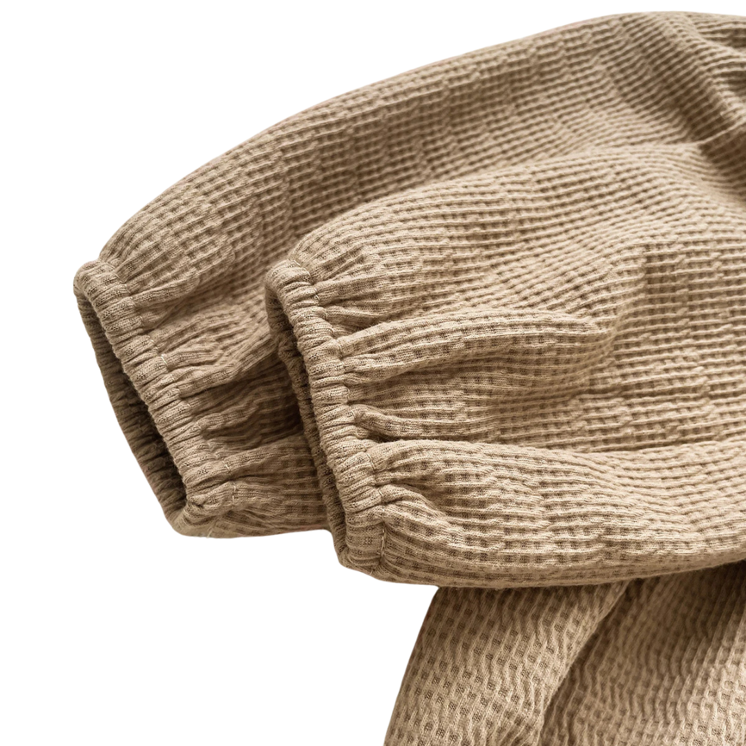 Detailed view of the cozy long sleeve elastic cuffs on the mocha brown autumn baby bodysuit.