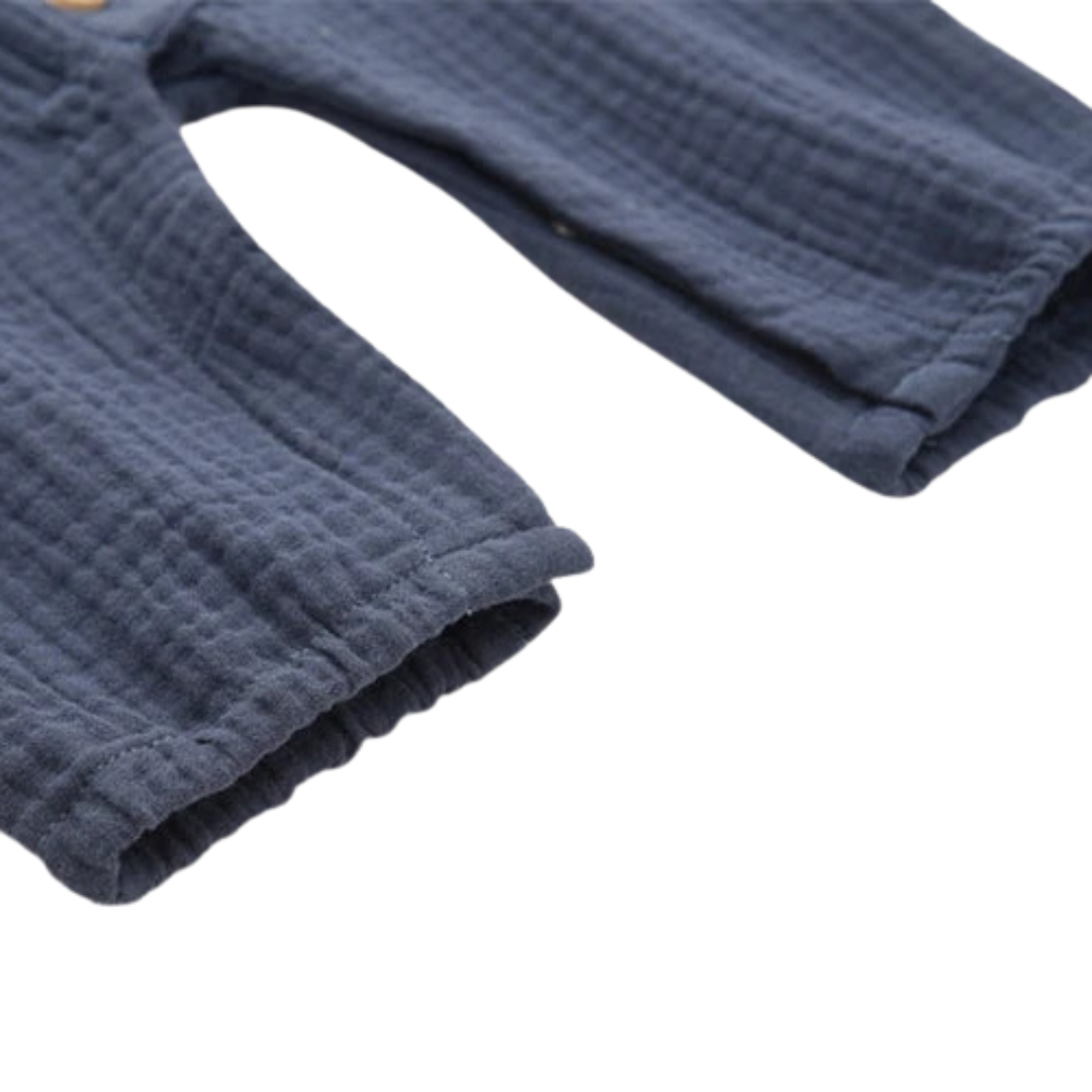 Close-up of the gently elasticated ankle cuff on the baby cotton muslin jumpsuit.