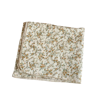 Folded mustard yellow floral 2-layer cotton muslin swaddle blanket on a pure white background.