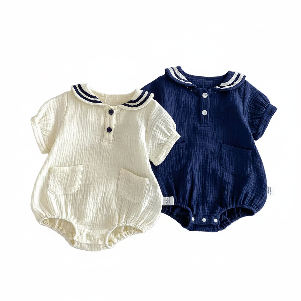 Flat lay showing both the Sea Salt and Deep Sea color options for the muslin sailor bubble romper together.