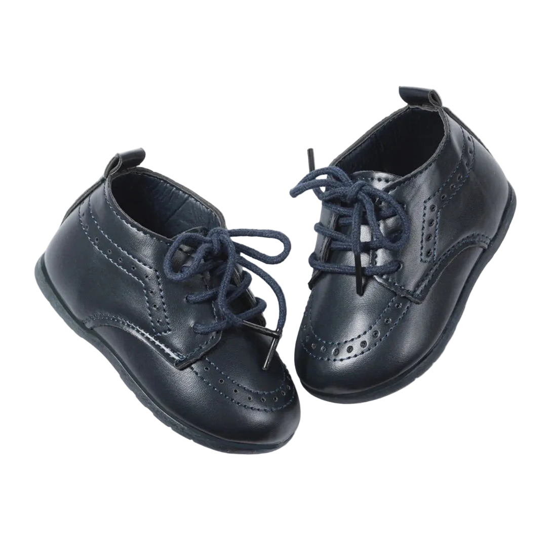 Pair of Kidsely navy blue smooth faux leather infant brogue oxfords angled on a clean white background.