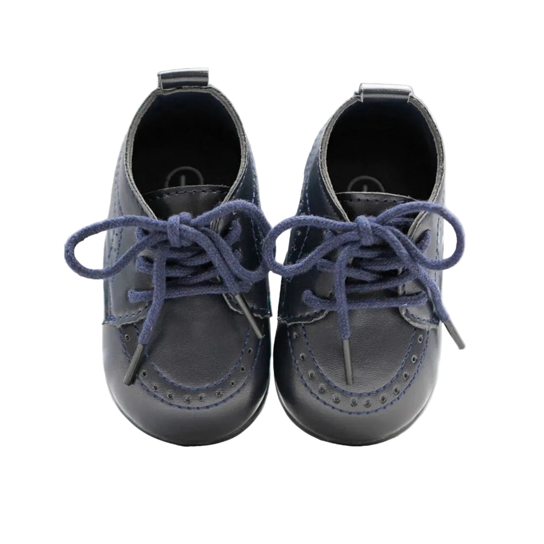 Front-facing view of a pair of Kidsely navy blue lace-up baby dress shoes showing the traditional brogue perforation detailing.