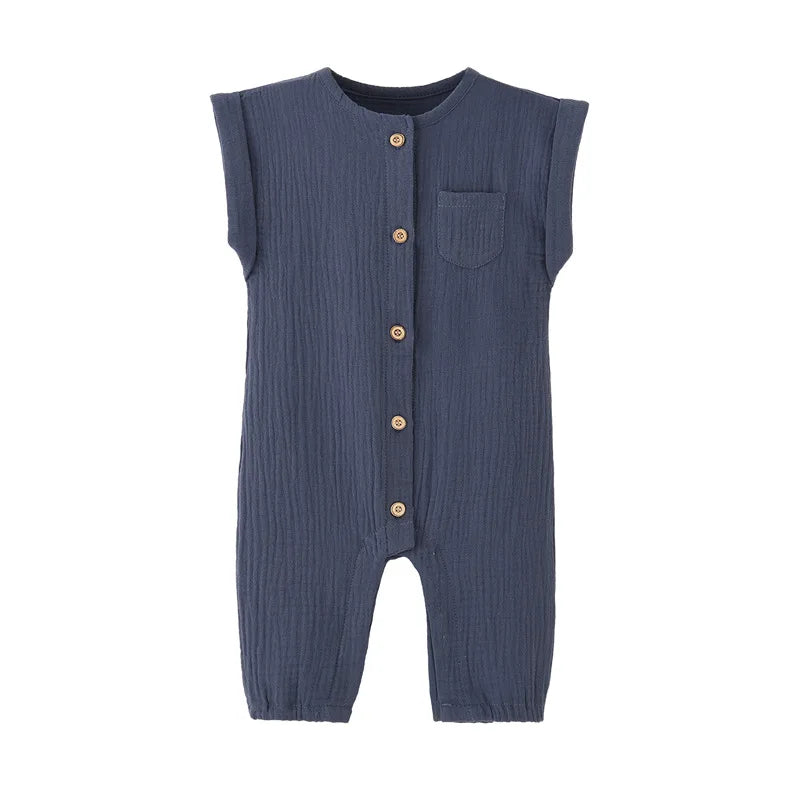 Front view of the vintage-inspired infant jumpsuit in navy blue, featuring a rolled cap sleeve, chest pocket, and rustic buttons.
