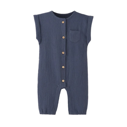 Front view of the vintage-inspired infant jumpsuit in navy blue, featuring a rolled cap sleeve, chest pocket, and rustic buttons.