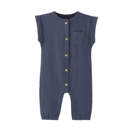 Front view of the vintage-inspired infant jumpsuit in navy blue, featuring a rolled cap sleeve, chest pocket, and rustic buttons.